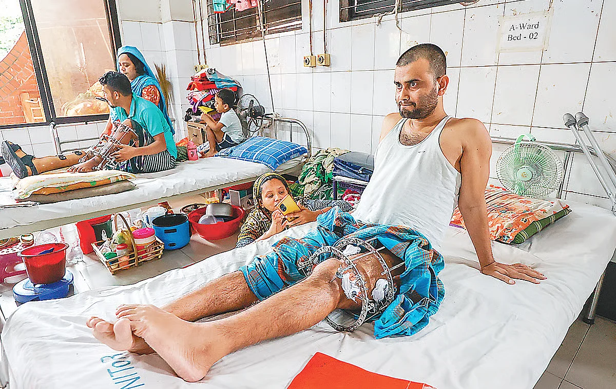 Shamim Mia, who was injured during the July mass uprising, sits on the hospital bed at the National Institute of Traumatology and Orthopaedic Rehabilitation (NITOR or Pangu Hospital) in Dhaka on 17 July 2025. 