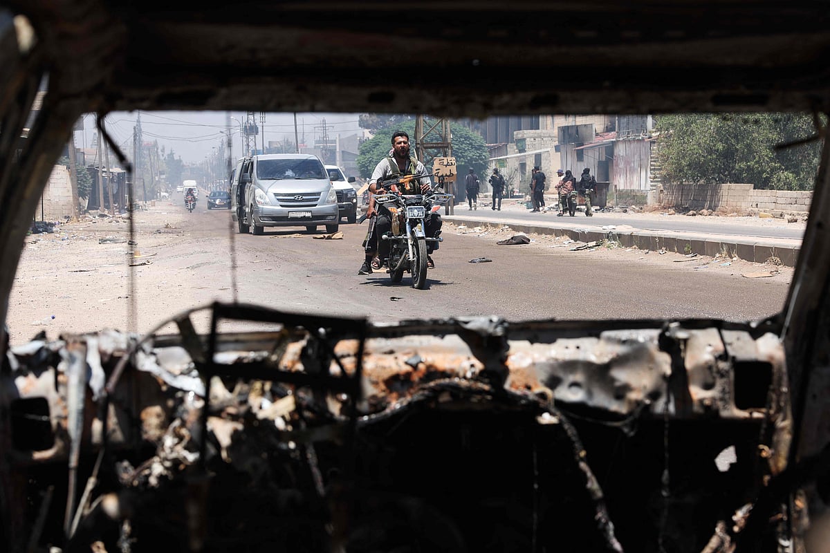 Tribal and bedouin fighters cross the al-Mazraa village in Syria's Sweida governorate as they mobilise amid clashes with Druze gunmen on 18 July, 2025. Armed tribes supported by Syria's Islamist-led government clashed with Druze fighters in the community's Sweida heartland on 18 July, a day after the army withdrew under Israeli bombardment and diplomatic pressure.
