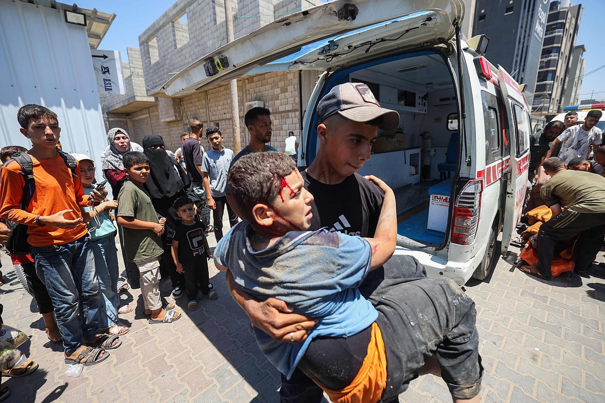 Palestinians transport casualties of an Israeli strike on an apartment at the Nuseirat refugee camp, into Al-Awda hospital in the central Gaza Strip on 19 July, 2025.