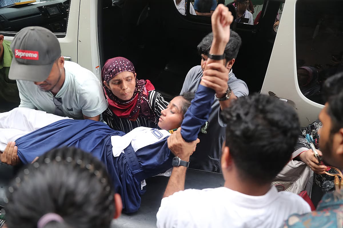 An injured student is being carried away from an ambulance.