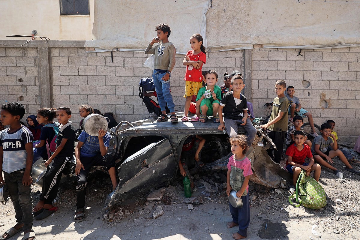 Palestinians children wait at a food distribution point in the Nuseirat refugee camp in the central Gaza Strip on 19 July, 2025.