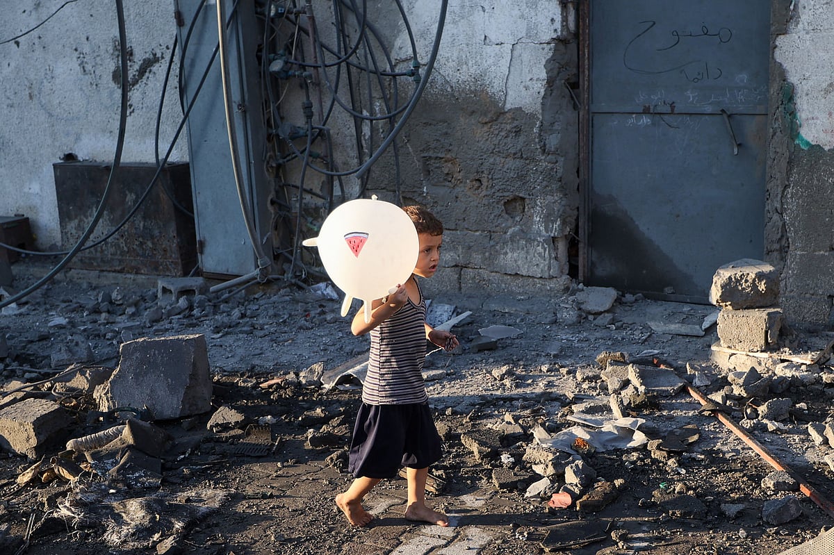 A Palestinian boy walks past debris after an Israeli strike on the Bureij refugee camp in the central Gaza Strip on 23 July, 2025