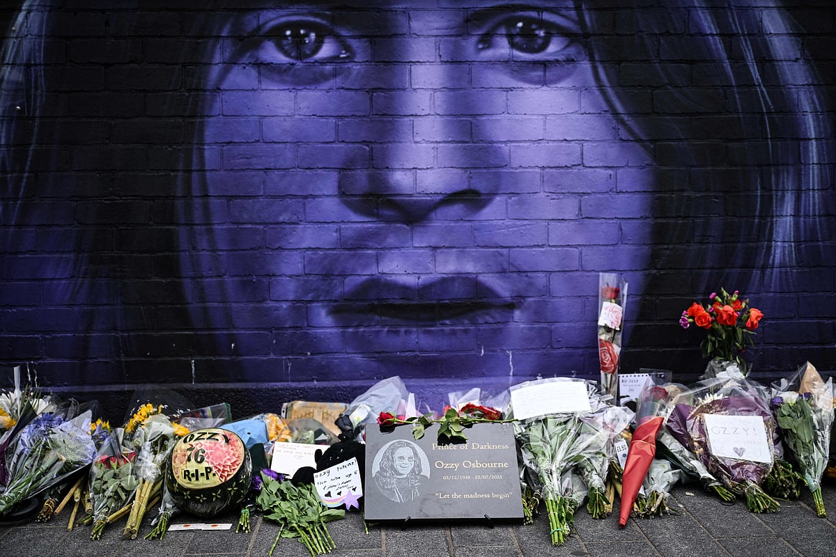 A photograph taken on 23 July, 2025 shows flowers, candles and drawings left at a makeshift memorial by a mural depicting late British singer-songwriter Ozzy Osbourne, in Birmingham, central England, a day after his death.