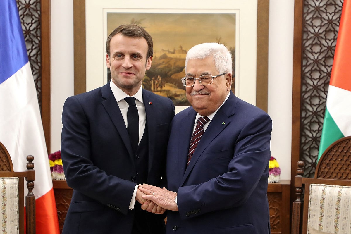 French President Emmanuel Macron (L) shakes hands with Palestinian President Mahmoud Abbas at his headquarters in the West Bank city of Ramallah, on 22 January, 2020.