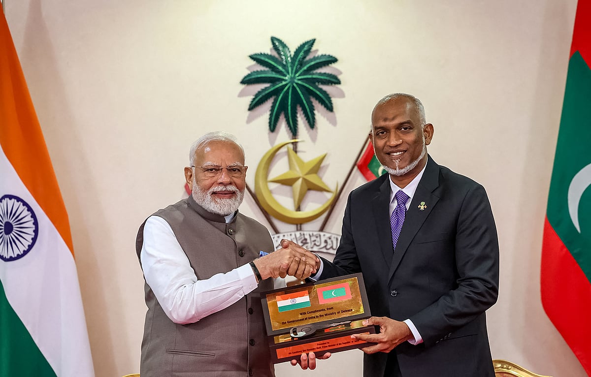 This handout photograph taken and released by the Indian Press Information Bureau (PIB) on 25 July 2025 shows President of Maldives Mohamed Muizzu (R) and India’s Prime Minister Narendra Modi posing ahead of exchanging a Memorandum of Understanding (MoU) in Male.