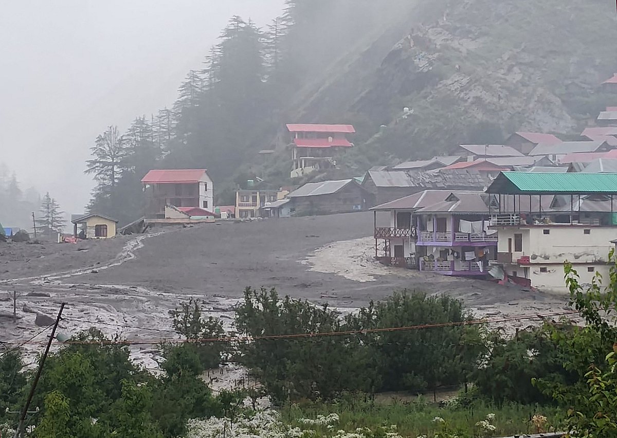 This handout photograph taken on August 5, 2025 and released by Uttarakhand's State Disaster Response Force (SDRF) shows muddy water running past residential buildings following a massive mudslide in India's Uttarakhand state