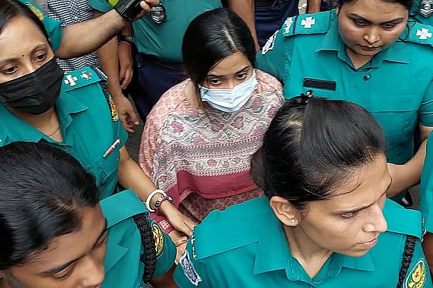 Police escorting Major Sadikul's wife, Jafrin, from the court to the detention cell.