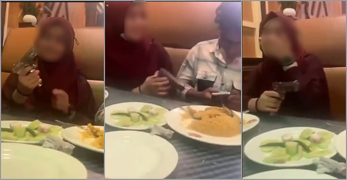 A young man and a woman seen sitting at a table at a restaurant, playfully handling a pistol in Sreepur upazila of Gazipur.