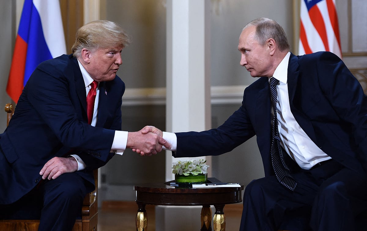 Russian President Vladimir Putin (R) and US President Donald Trump shake hands before a meeting in Helsinki on 16 July 2018.