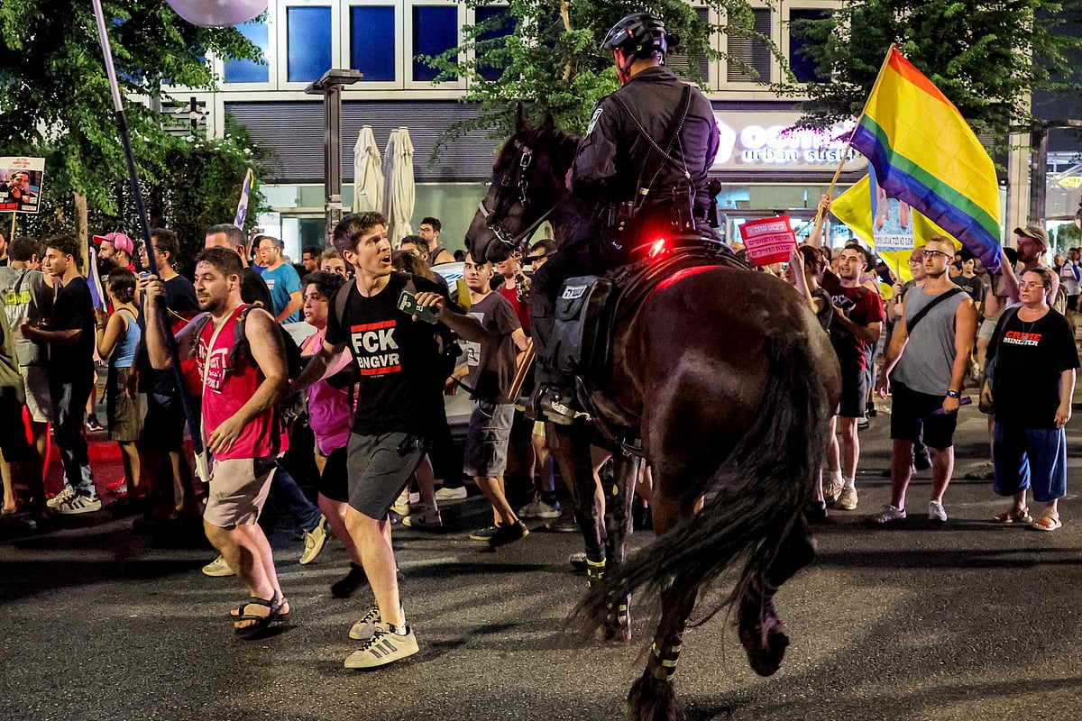 A protester confronts a mounted Israeli policeman attempting to disperse people gathered for a demonstration organised by the families of the Israeli hostages taken captive in the Gaza Strip since the October 2023 calling for action to secure their release, by Azrieli Centre outside the Defence Ministry headquarters in Tel Aviv on 9 August, 2025