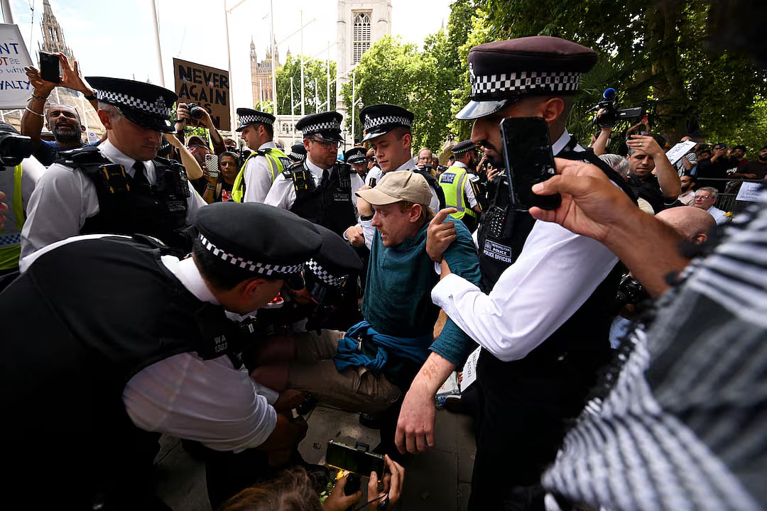 Police officers detain a demonstrator during a rally organised by Defend Our Juries, challenging the British government's proscription of "Palestine Action" under anti-terrorism laws, in Parliament Square, in London, Britain, 9 August, 2025.