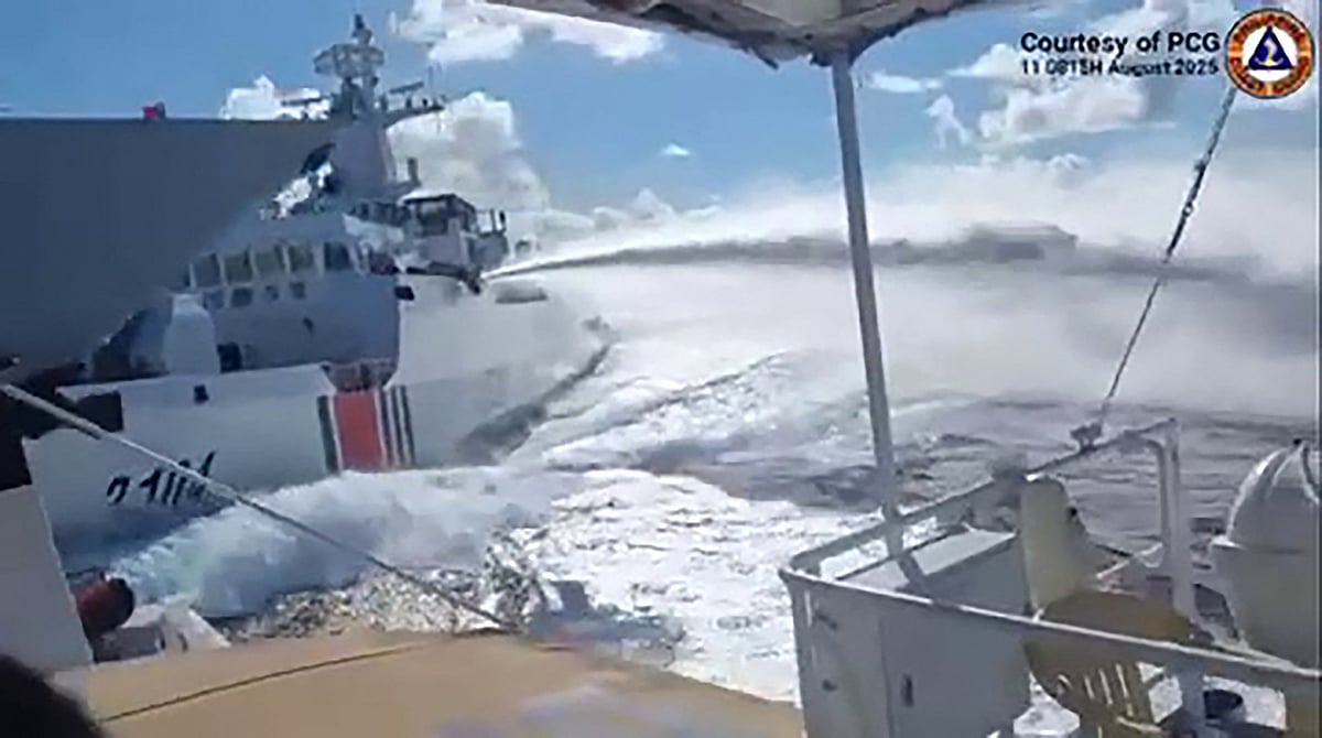 This handout video grab released and taken on 11 August 2025 by the Philippine Coast Guard shows an incident between a Chinese Navy vessel (far L, bow pictured) and a Chinese Coast Guard ship (2nd L) as seen from a Philippine fisheries boat near Scarborough Shoal in the disputed South China Sea.