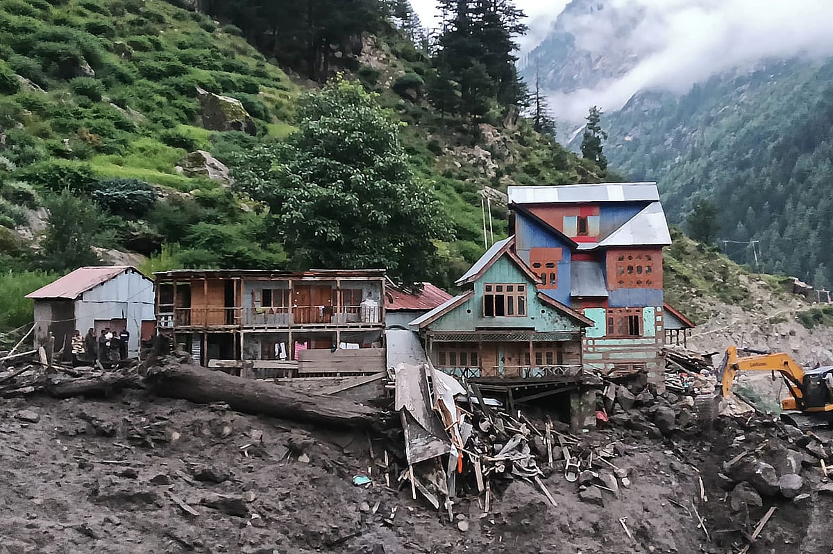 Rescuers (L) inspect the site of a flashflood at a village in Kishtwar district on August 14, 2025