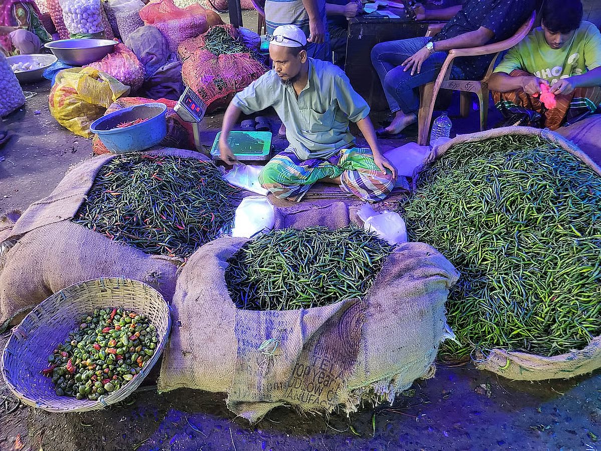 A retailer sells green chilli at Karwan Bazar, Dhaka