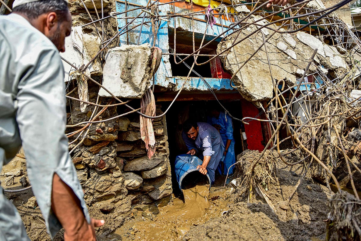 A resident removes sludge from his damaged house a day after flash floods in the Buner district of the monsoon-hit northern Pakistan's mountainous Khyber Pakhtunkhwa province on 16 August, 2025.