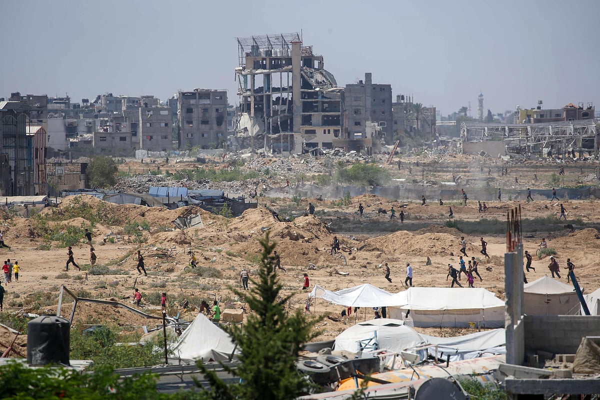 Displaced Palestinians make their way towards the site of a humanitarian aid airdrop at the Bureij camp in the central Gaza Strip, on 17 August 2025. After more than 22 months of war, UN-backed experts have warned of widespread famine unfolding in Gaza, where Israel has drastically curtailed the amount of humanitarian aid it allows in and convoys have been repeatedly looted.