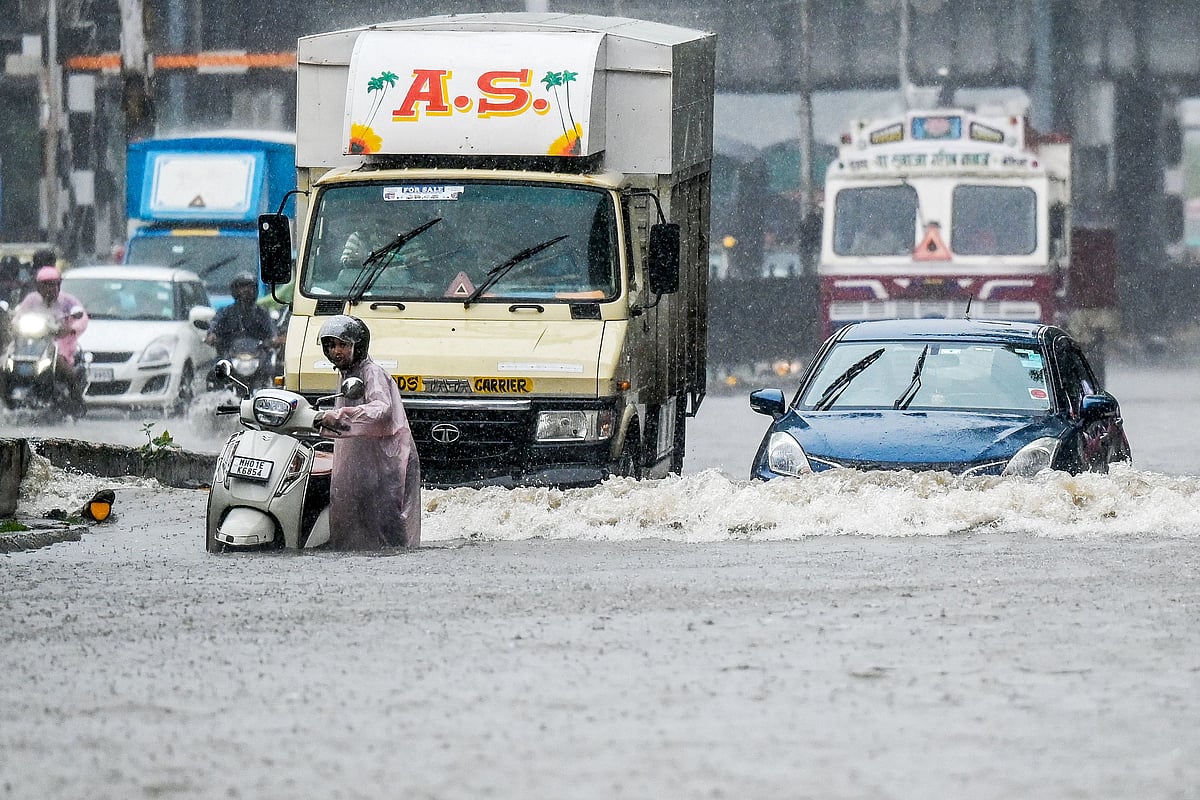 Vehicles wade through a flooded street during heavy rain showers in Mumbai on 18 August 2025.