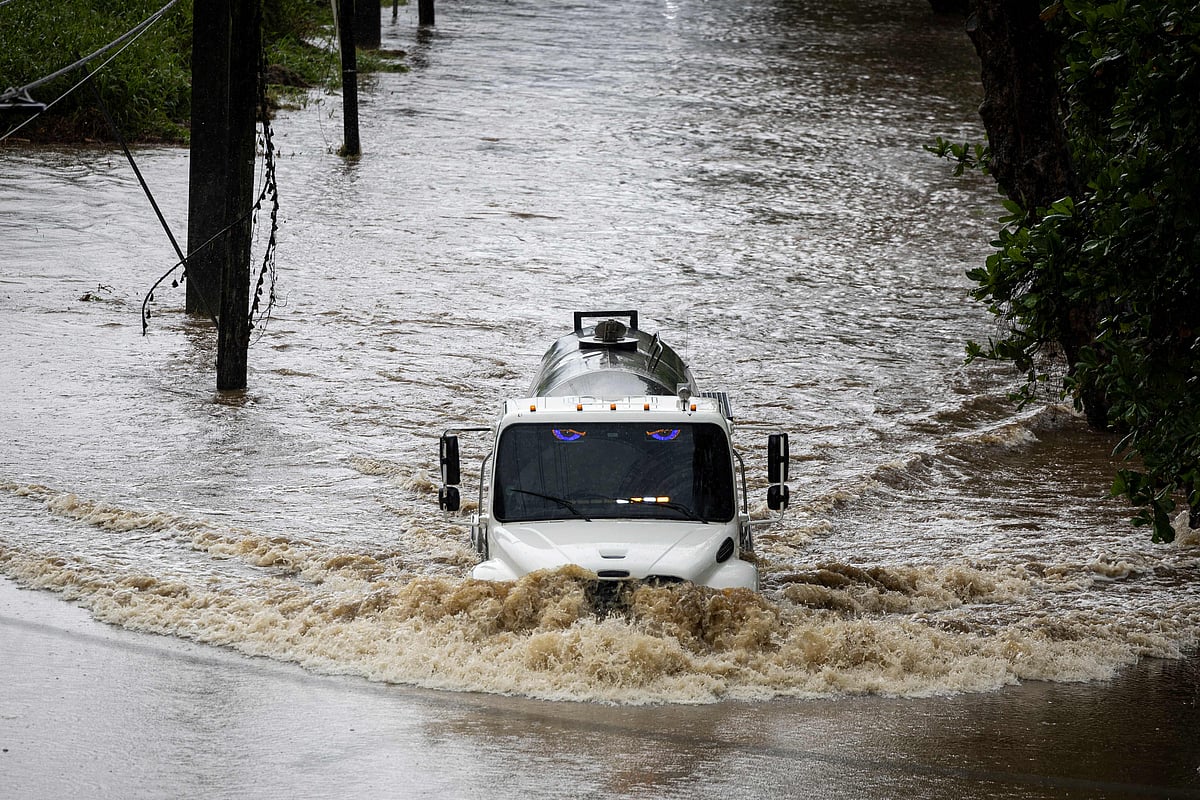 A truck drives through a flooded road as category 3 Hurricane Erin leaves the region in Naguabo, Puerto Rico on August 16, 2025. Offshore Hurricane Erin was downgraded to a Category 3 storm early Sunday, as rain lashed Caribbean islands and weather officials warned of possible flash floods and landslides