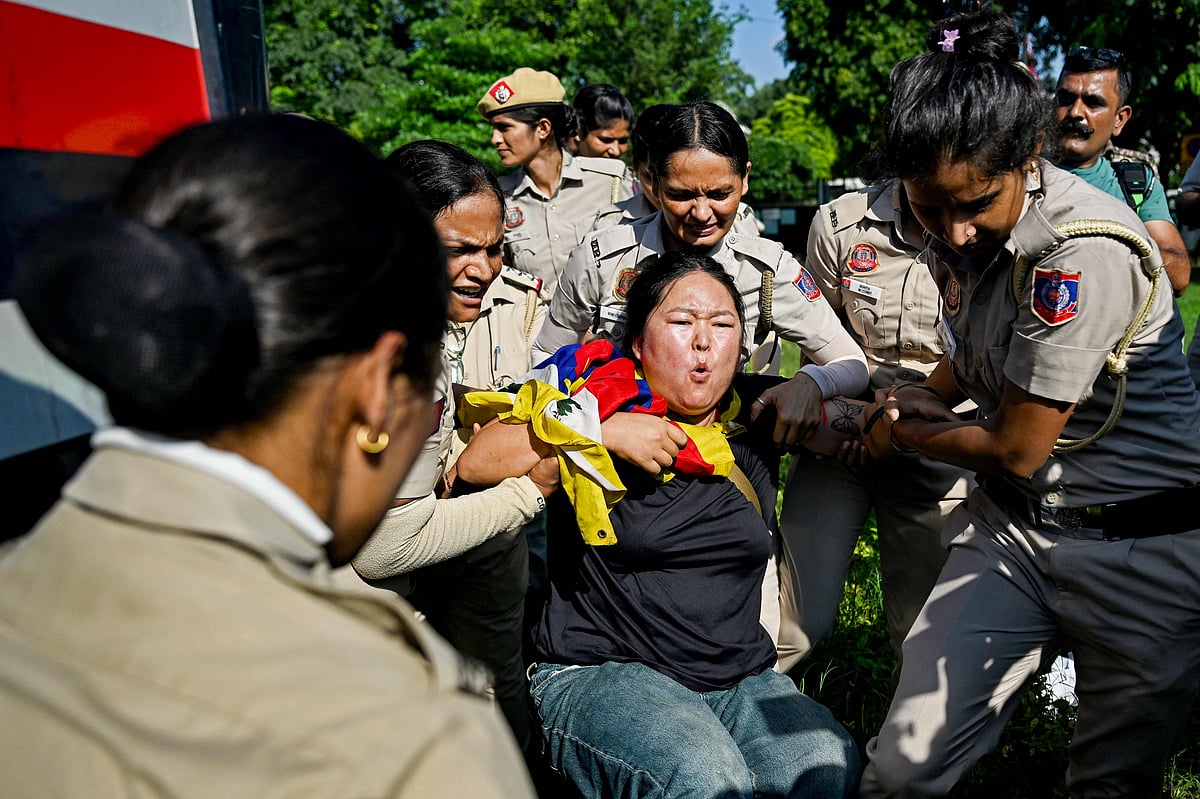 Police personnel detain a Tibetan protester near the Chinese embassy during a demonstration on the sidelines of China's Foreign Minister Wang Yi's visit to New Delhi on 18 August 2025.