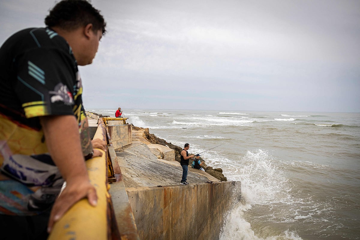 Fishermen take advantage of the swollen Río Grande de Arecibo at its mouth after category 3 Hurricane Erin passed through the region in Arecibo, Puerto Rico, on August 17, 2025