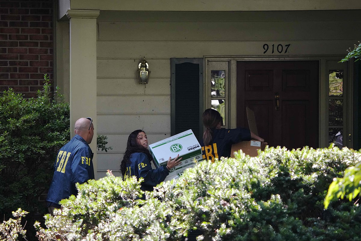 FBI agents carry boxes into the home of John Bolton, former national security adviser to President Trump, 22 August 2025 in Bethesda, Maryland.