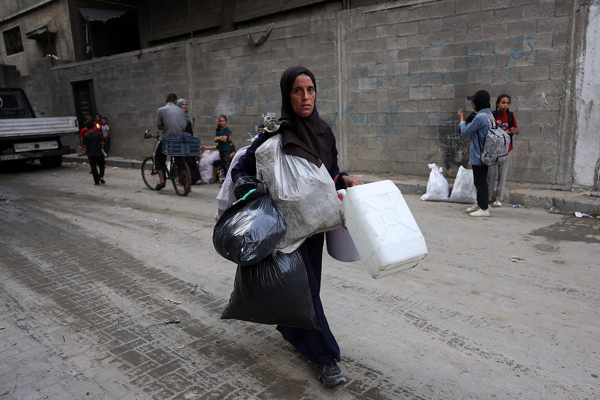 A Palestinian woman carries her belongings as she flees the Abu Iskandar neighbourhood of northern Gaza City on 22 August 2025.
