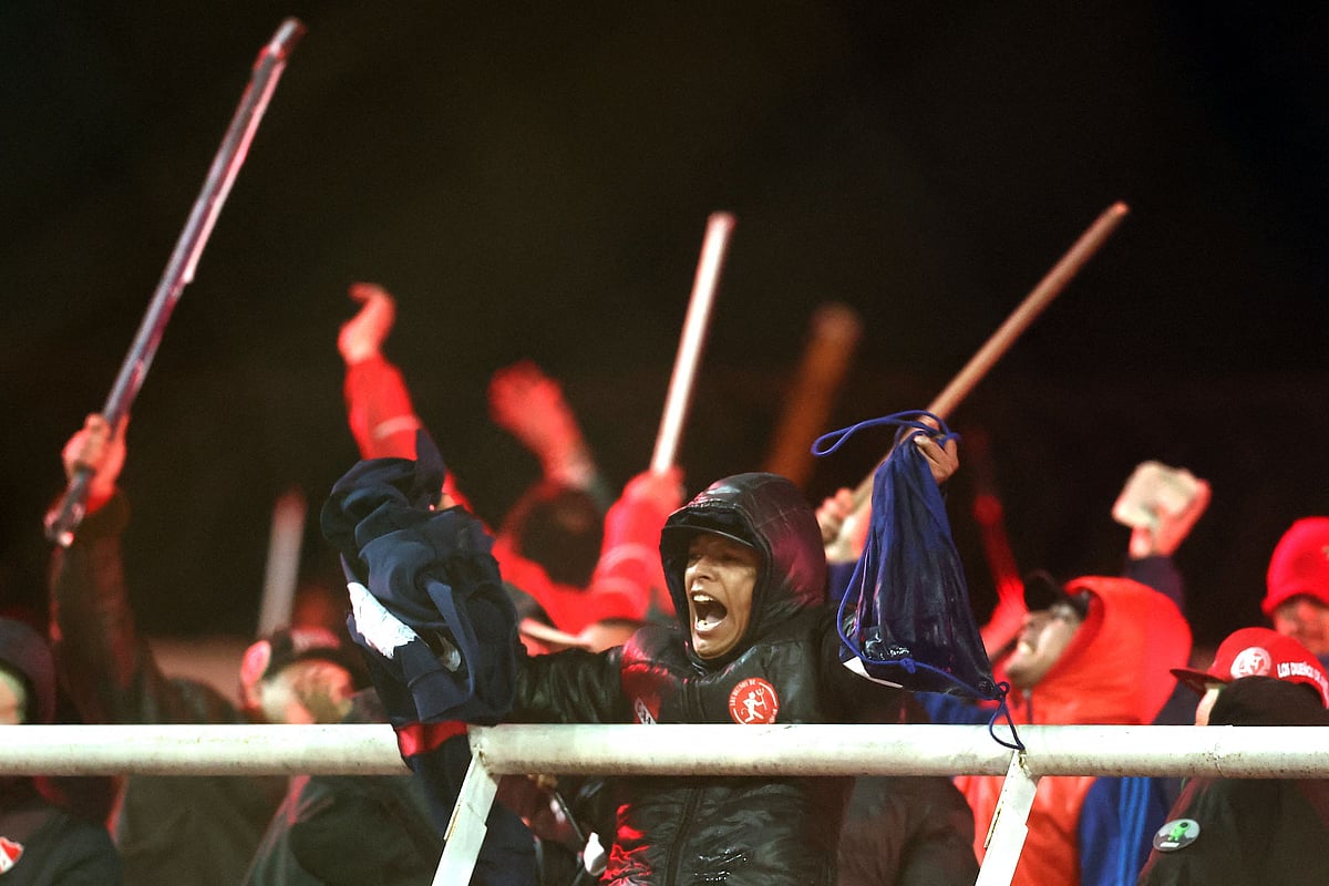 Independiente fans display stolen clothing and brandish sticks at the stands where Universidad de Chile fans were sitting during the interruption of the Copa Sudamericana round of 16 second leg football match between Argentina's Independiente and Chile's Universidad de Chile at the Libertadores de America stadium in Avellaneda, Buenos Aires province, Argentina, on 20 August, 2025.
