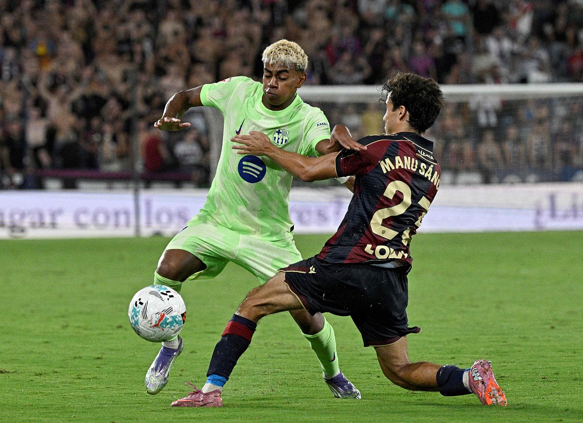 Barcelona's Spanish forward #10 Lamine Yamal fights for the ball with Levante's Spanish defender #23 Manu Sanchez during the Spanish league football match between Levante UD and FC Barcelona at Ciutat de Valencia Stadium in Valencia on 23 August, 2025.