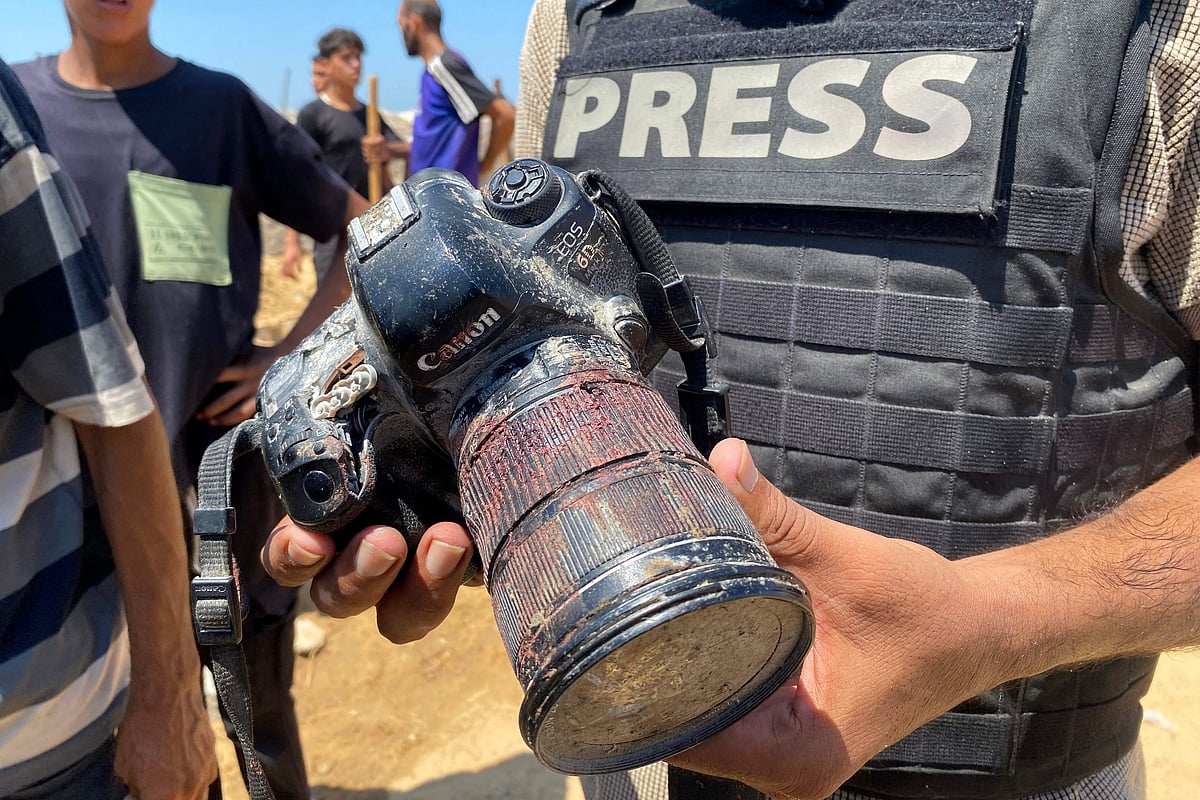 A journalist holds the blood-covered camera belonging to Palestinian photojournalist Mariam Dagga, a journalist who freelanced for AP since the start of the war and who was killed in an Israeli strike on Nasser hospital in Khan Yunis in the southern Gaza Strip, during her funeral on 25 August, 2025.