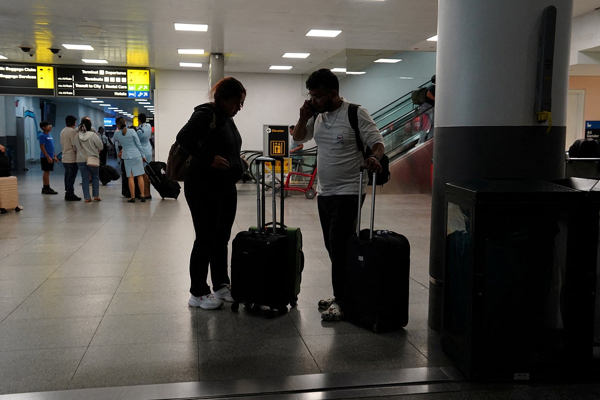 Travelers use a mobile phone at Terminal 8 at John F. Kennedy International Airport in New York, U.S., 8 June 2025.