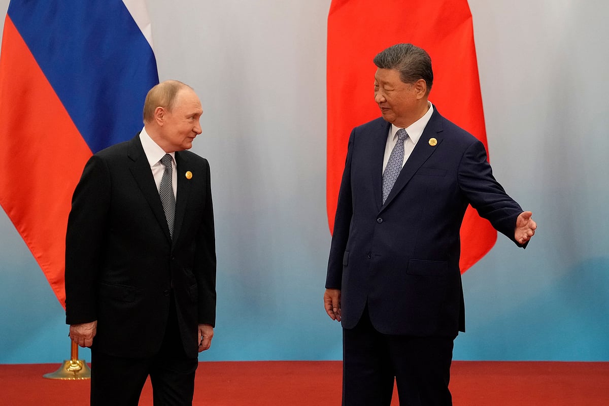 Chinese President Xi Jinping (R) shows the way to Russian President Vladimir Putin after the photo session of the Shanghai Cooperation Organization (SCO) Summit 2025 at the Meijiang Convention and Exhibition Centre in Tianjin on 1 September 2025