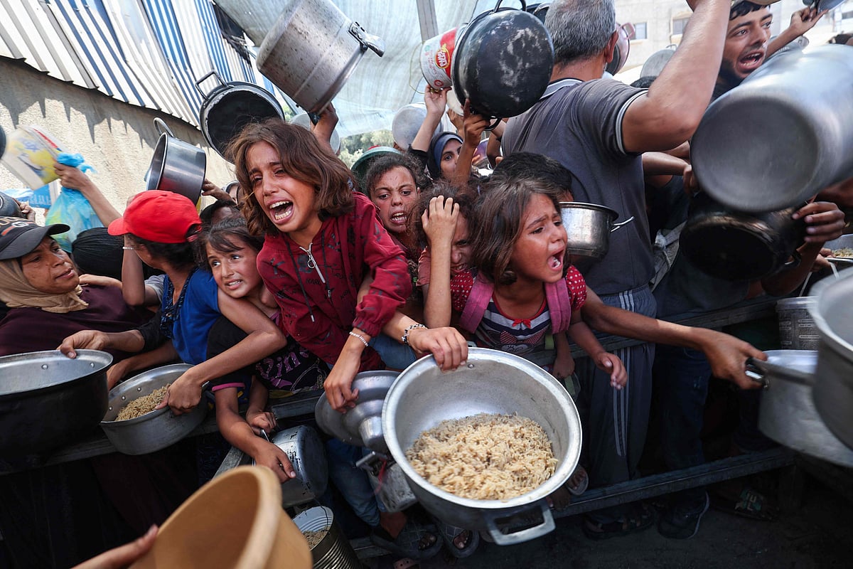 Palestinians shove to receive a hot meal from a charity kitchen in the Nuseirat refugee camp in the Israel-besieged Gaza Strip on 4 September, 2025, where the UN has declared famine after nearly two years of war.