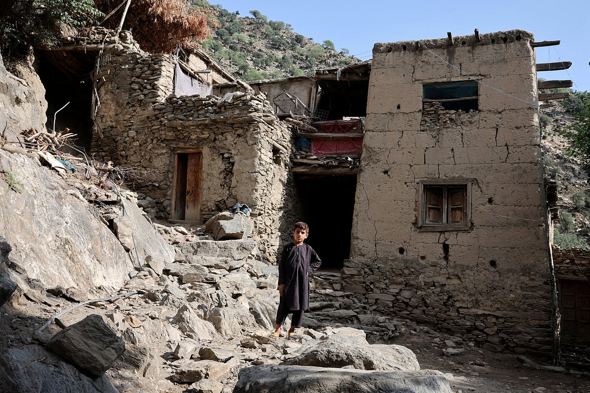 A boy stands in front of houses damaged by a deadly earthquake that struck Afghanistan's Kunar and Nangarhar provinces, at Masud village in Nurgal district, Kunar province, Afghanistan, 4 September 2025.