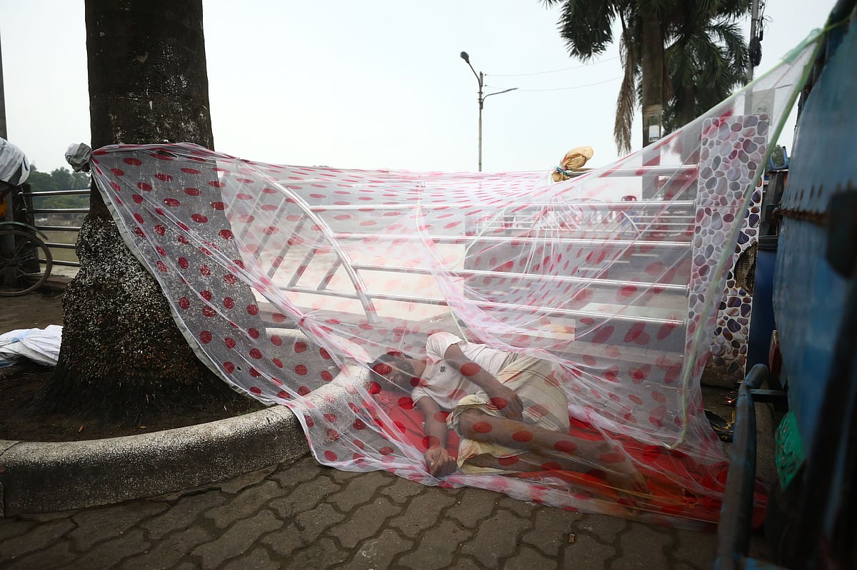 A man sleeps under a mosquito net pitched in the open beside the road. Photo taken from Keane Bridge area in Sylhet on 9 September 2025. 