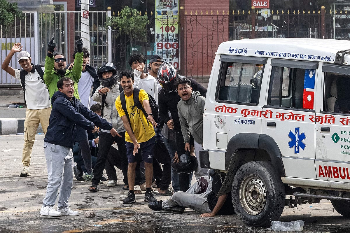 Demonstrators react after a person is injured in a clash with riot police personnel during a protest outside the Parliament in Kathmandu on September 8, 2025, against the social media prohibitions and corruption by the government
