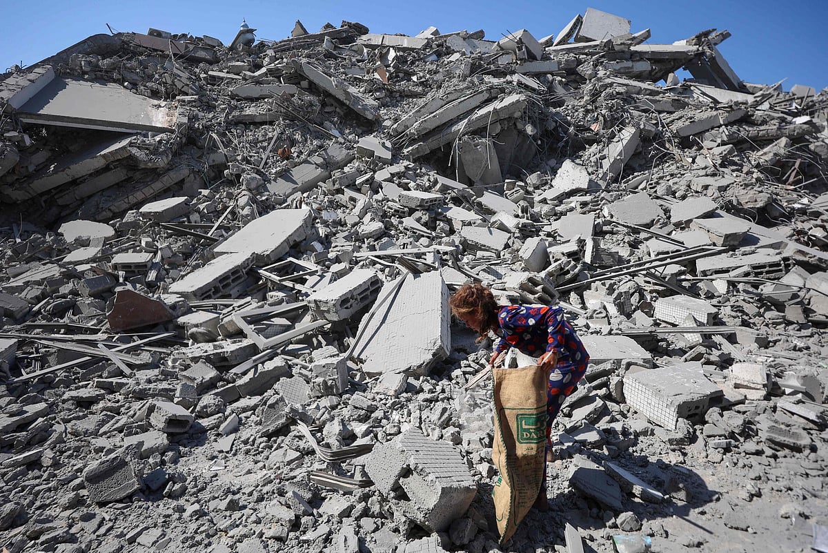 A Palestinian girl searches the rubble of al-Ghafari tower after its destruction by Israeli airstrikes in Gaza City on 15 September 2025