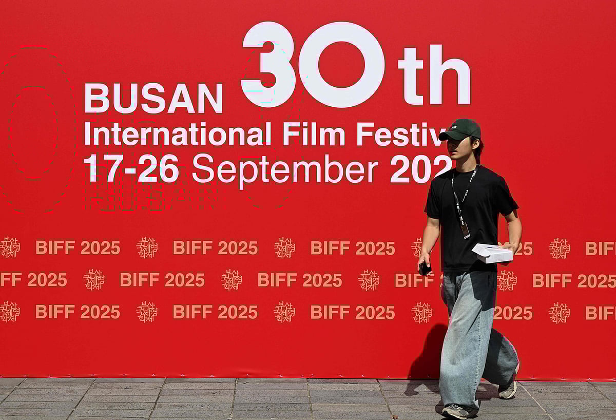 A man walks past a sign for the 30th Busan International Film Festival (BIFF) at the Busan Cinema Center in Busan on 17 September, 2025.
