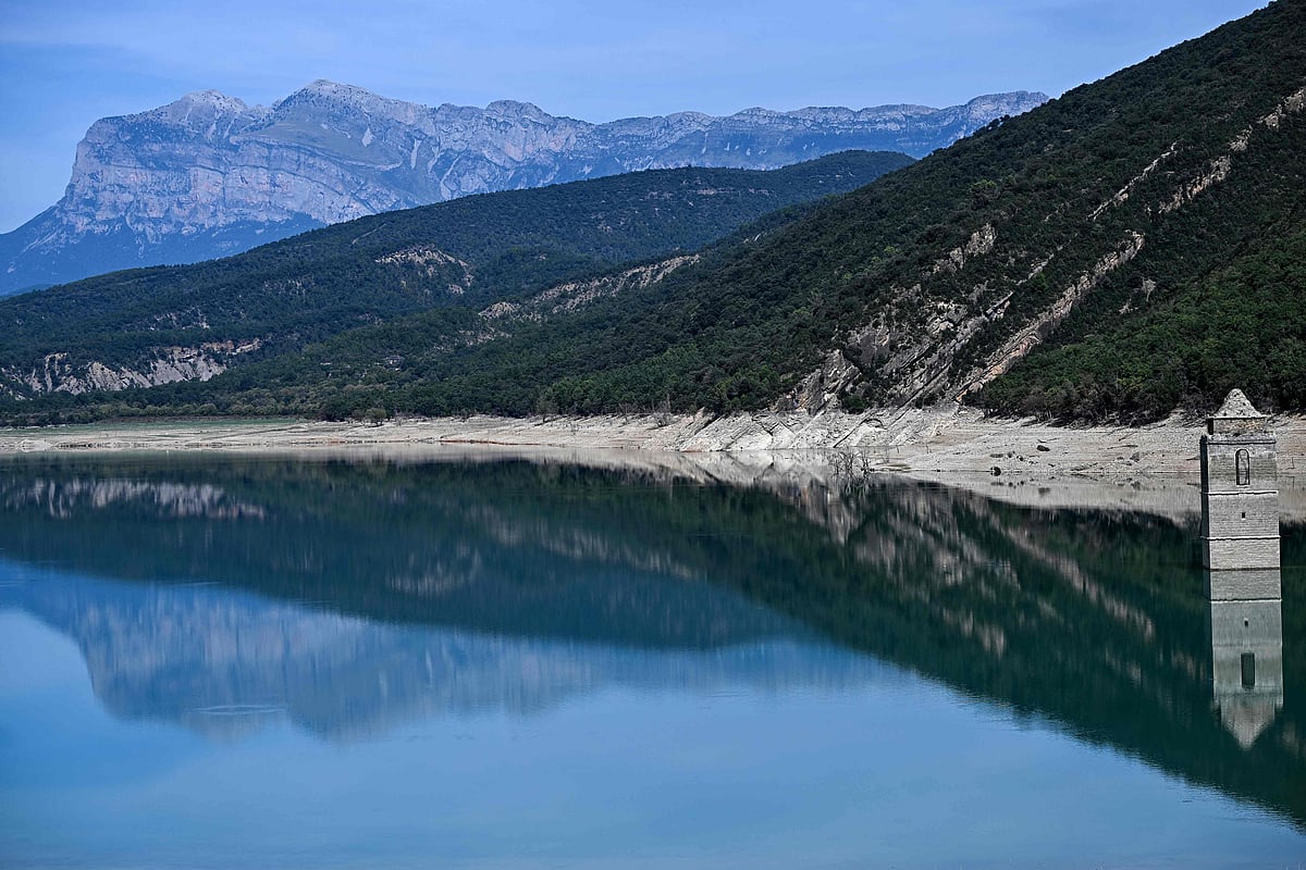 This photograph taken on 17 September, 2025 shows a view of the Mediano reservoir, with the Church of Asuncion of Mediano partially visible amid low water-level, in Mediano, Huesca province. This long-term project shows an inventory of several sites in Spain which are suffering from drought. Photos of the same places are taken every month over a very long period.
