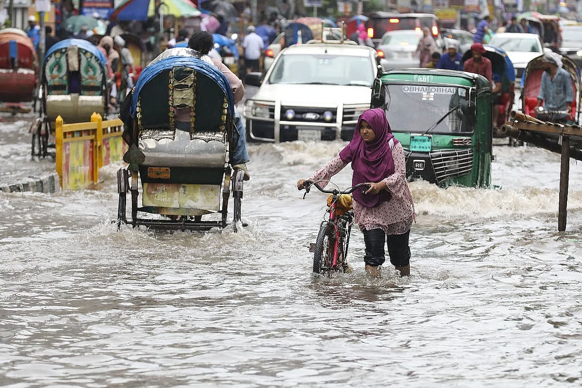 Waterlogging on Dhaka’s Green Road due to rain. A woman wades with difficulties with her bicycle through the rainwater accumulated on Green Road in Dhaka. Photo taken around 9:45 am on 22 September 2025.