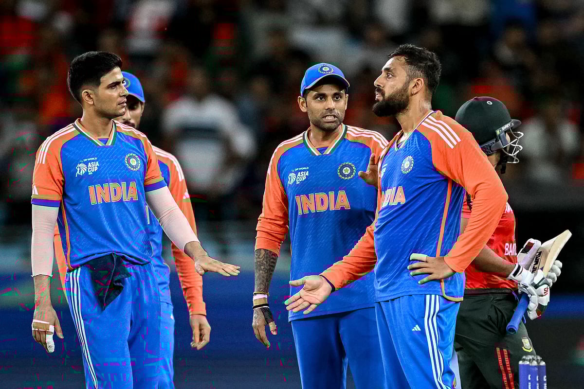 India's Varun Chakravarthy (R) celebrates with teammates after taking the wicket of Bangladesh's Shamim Hossain during the Asia Cup 2025 Super Four Twenty20 international cricket match between Bangladesh and India at the Dubai International Stadium in Dubai on September 24, 2025.
