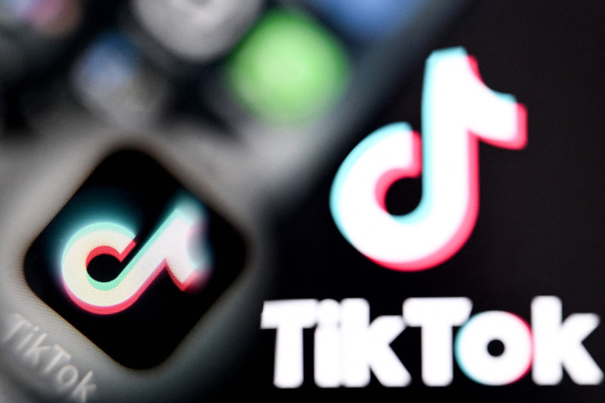 A photo taken on 10 April 2025 shows the Chinese social networking service TikTok's logos on a smartphone screen (L) and laptop screen in Frankfurt am Main, western Germany.