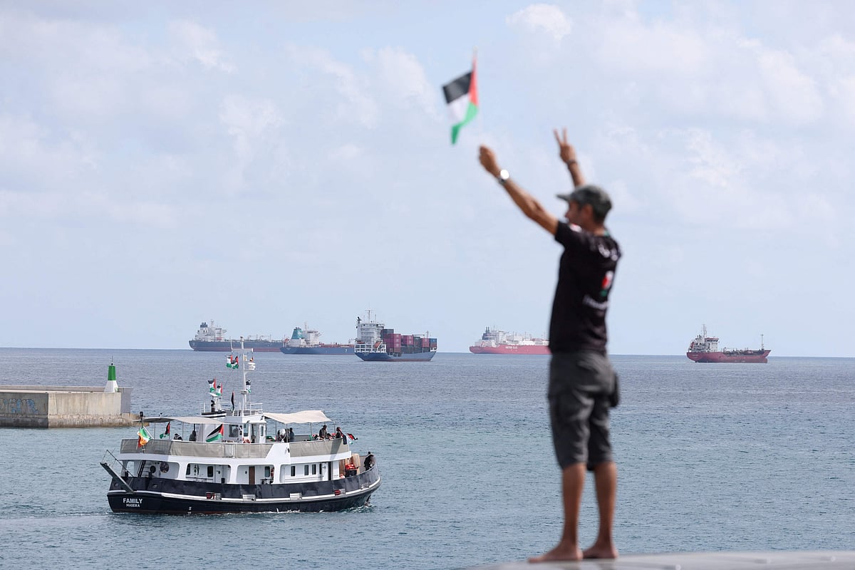 An activist waves the Palestinian flag as a boat carrying Swedish climate activist Greta Thunberg and activists, part of a civilian flotilla aiming at breaking the Israeli blockade of the Gaza Strip, leaves the port of Barcelona, on 31 August 2025