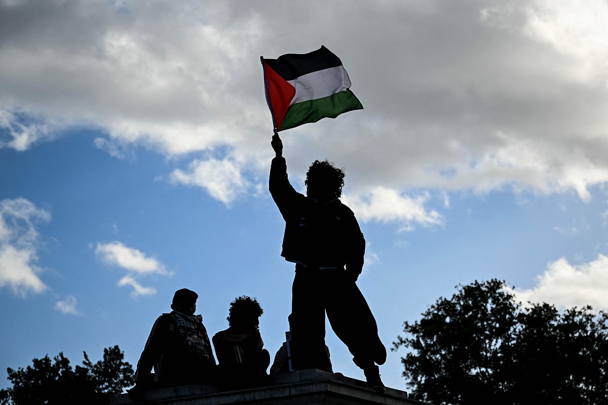 A demonstrator holds a Palestinian flag during a rally in solidarity with Palestinians and to protest against the interception by the Israeli navy of the Global Sumud Flotilla, in Paris on 4 October, 2025