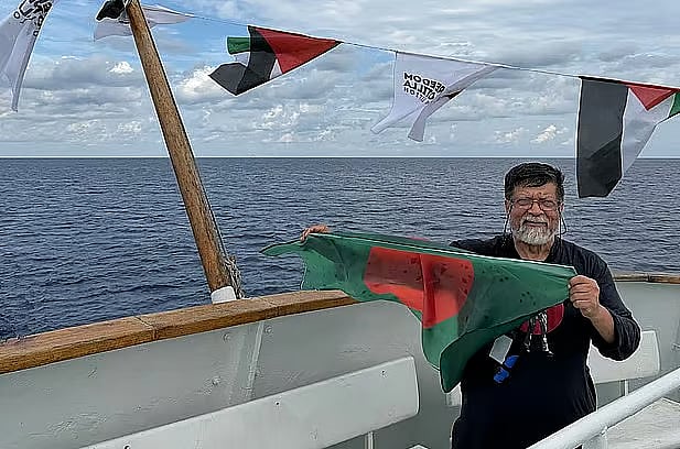 Shahidul Alam holds a national flag of Bangladesh