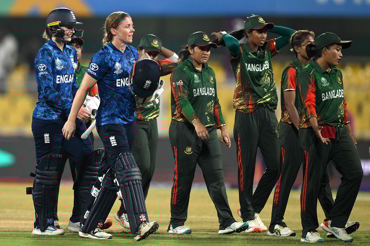 Bangladesh’s players (R) along with England’s Heather Knight and Charlie Dean walk back to the pavilion at the end of the 2025 ICC Women’s Cricket World Cup one-day international (ODI) match between Bangladesh and England at the Barsapara Cricket Stadium in Guwahati on 7 October 2025