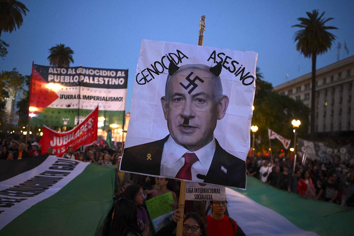 A demonstrator displays a photo of Israeli Prime Minister Benjamin Netanyahu with a swastika drawn on his forehead and the words "genocidal" and "murderer" during a march in Buenos Aires on 7 October, 2025