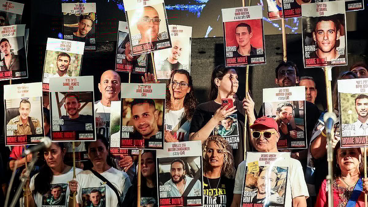 People hold placards with pictures of hostages who taken hostage in the deadly 7 October, 2023 attack by Hamas.