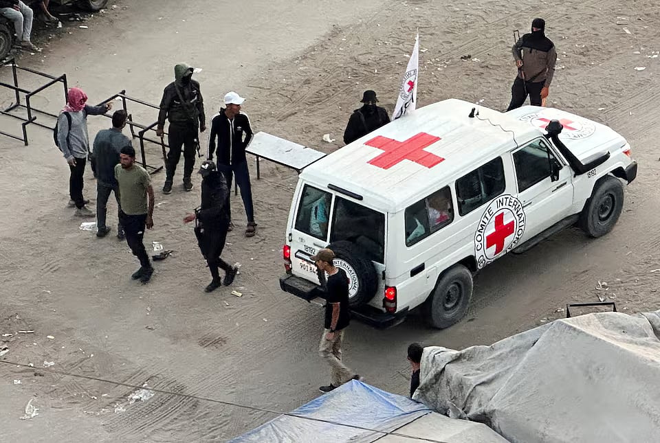 A Red Cross vehicle moves along a road before the expected release of hostages held in Gaza, in Khan Younis, southern Gaza Strip.
