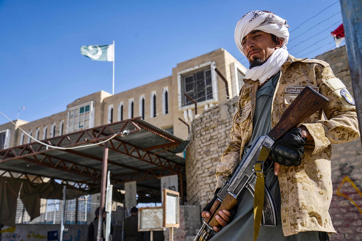 An Armed Taliban security personnel stands guard near the closed gate of the zero point border crossing between Afghanistan and Pakistan at Spin Boldak district in Kandahar province on October 12, 2025
