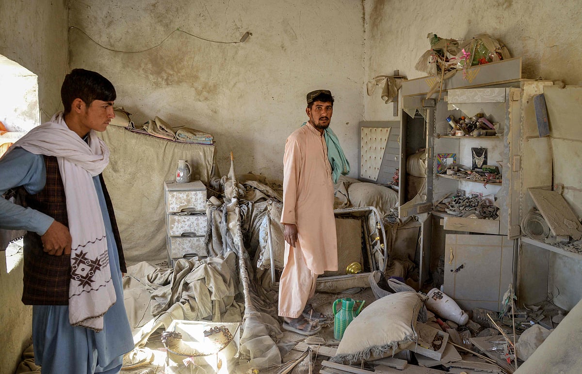Afghan men inspect a damaged house after a Pakistani airstrike hits during ongoing clashes between Taliban security personnel and Pakistani border forces in the Spin Boldak district of Kandahar province on October 15, 2025